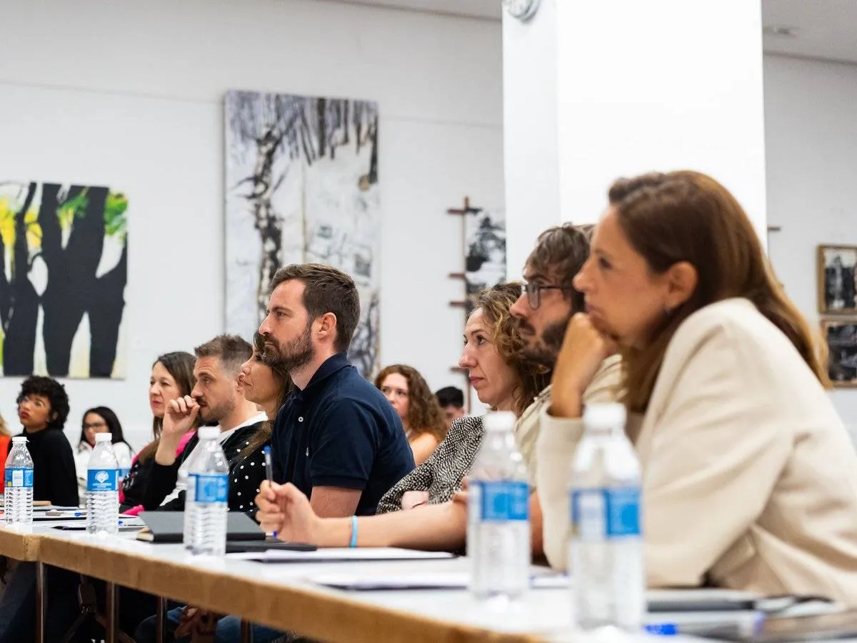Participantes trabajando y tomando notas en una mesa larga